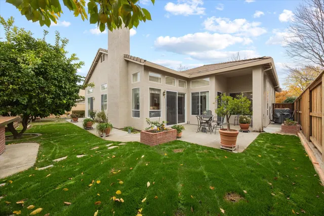 a view of a house with backyard and sitting area