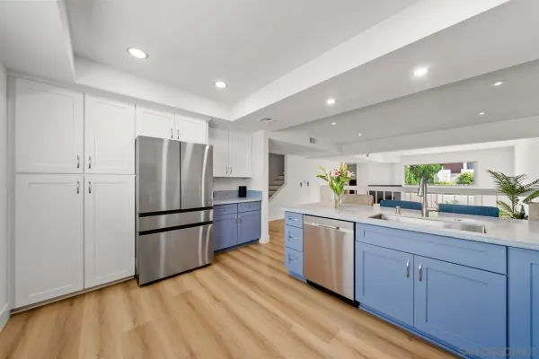a kitchen with kitchen island white cabinets and stainless steel appliances