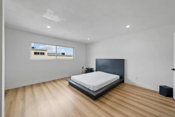 a bedroom with a bed and wooden floor