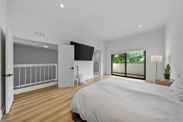 a spacious bedroom with a bed and a flat screen tv