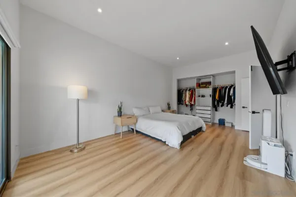 a spacious bedroom with a bed and a flat screen tv
