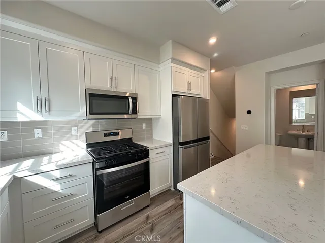 a kitchen with a refrigerator and a stove top oven