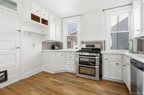 a kitchen with cabinets stainless steel appliances and wooden floor