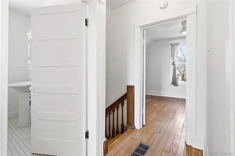 a view of a hallway with wooden floor and entryway