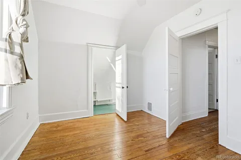 a view of empty room with wooden floor