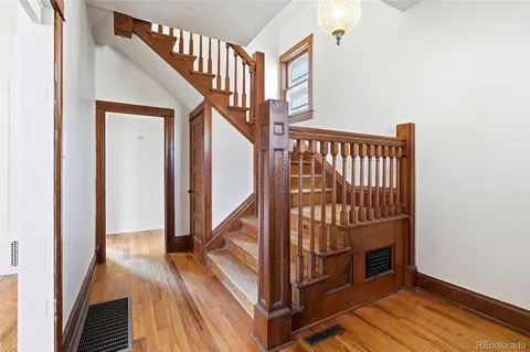 a view of staircase with wooden floor and a rug