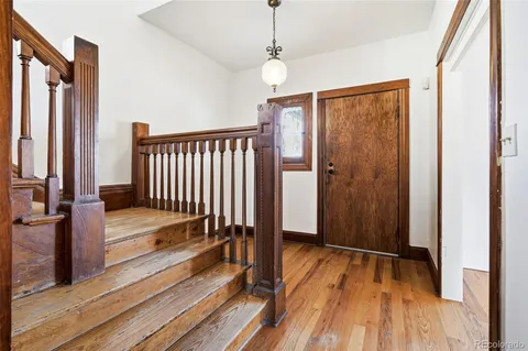 a view of a hallway with wooden floor and staircase