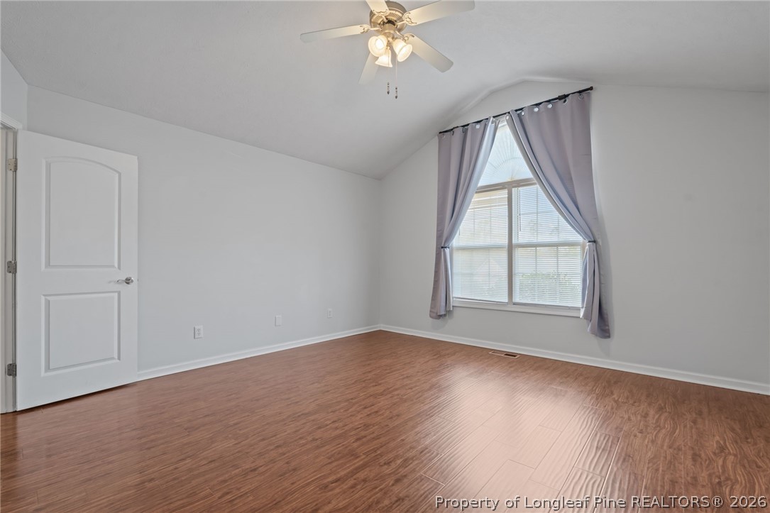115 Shelby Street Spring Lake, NC 28390 - Photo 22 of 40 an empty room with wooden floor chandelier fan and windows