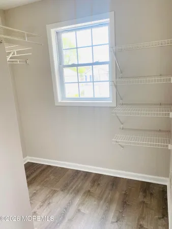 a view of a small space with wooden floor and a window
