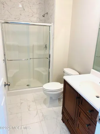 a bathroom with a shower a toilet and a sink