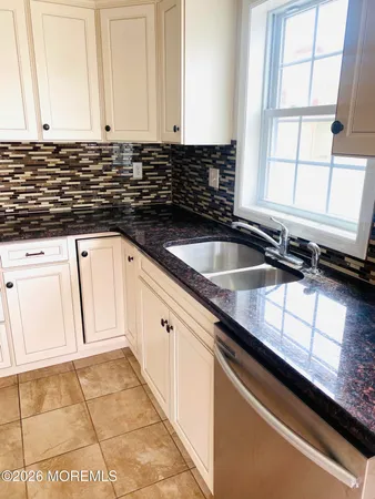 a kitchen with granite countertop a sink and a white stove