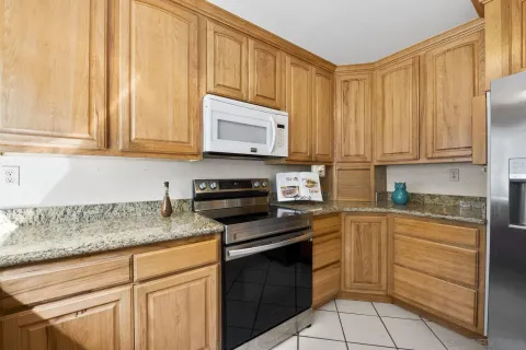 a kitchen with stainless steel appliances granite countertop a stove a sink and a microwave