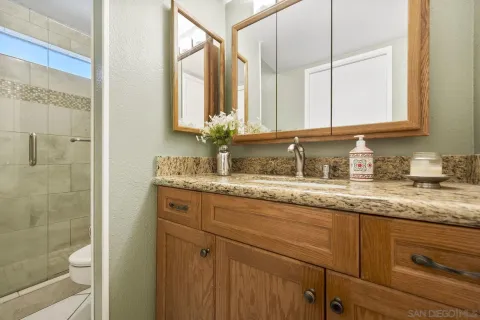 a bathroom with a granite countertop sink and a mirror