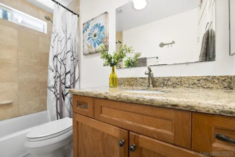a bathroom with a granite countertop sink a toilet and a mirror