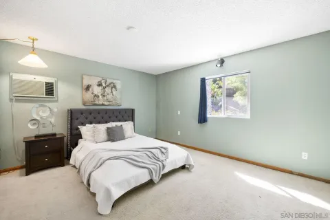 a bedroom with a bed and a painting on the wall