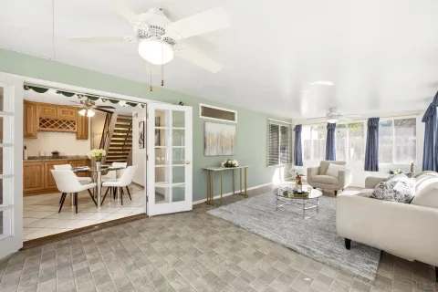 a living room with furniture a chandelier and a dining table