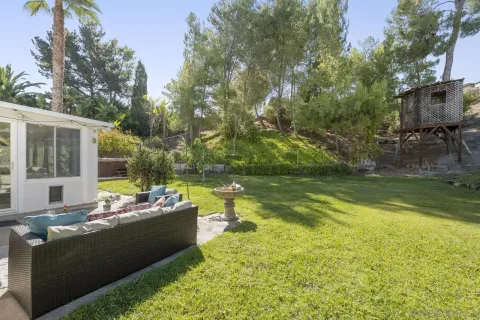 a view of a swimming pool with chairs in front of house