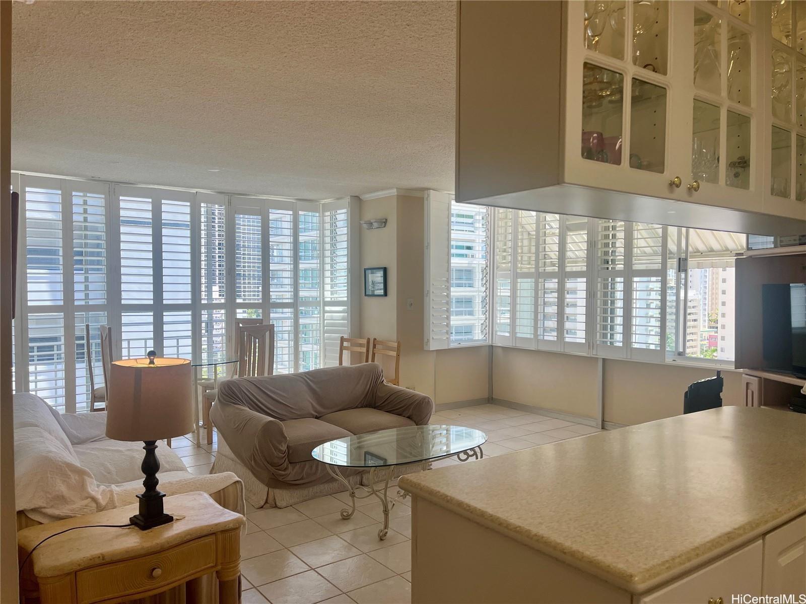 2415 Ala Wai Boulevard, Unit 1208 Honolulu, HI 96815 - Photo 1 of 13 a living room with furniture and floor to ceiling windows