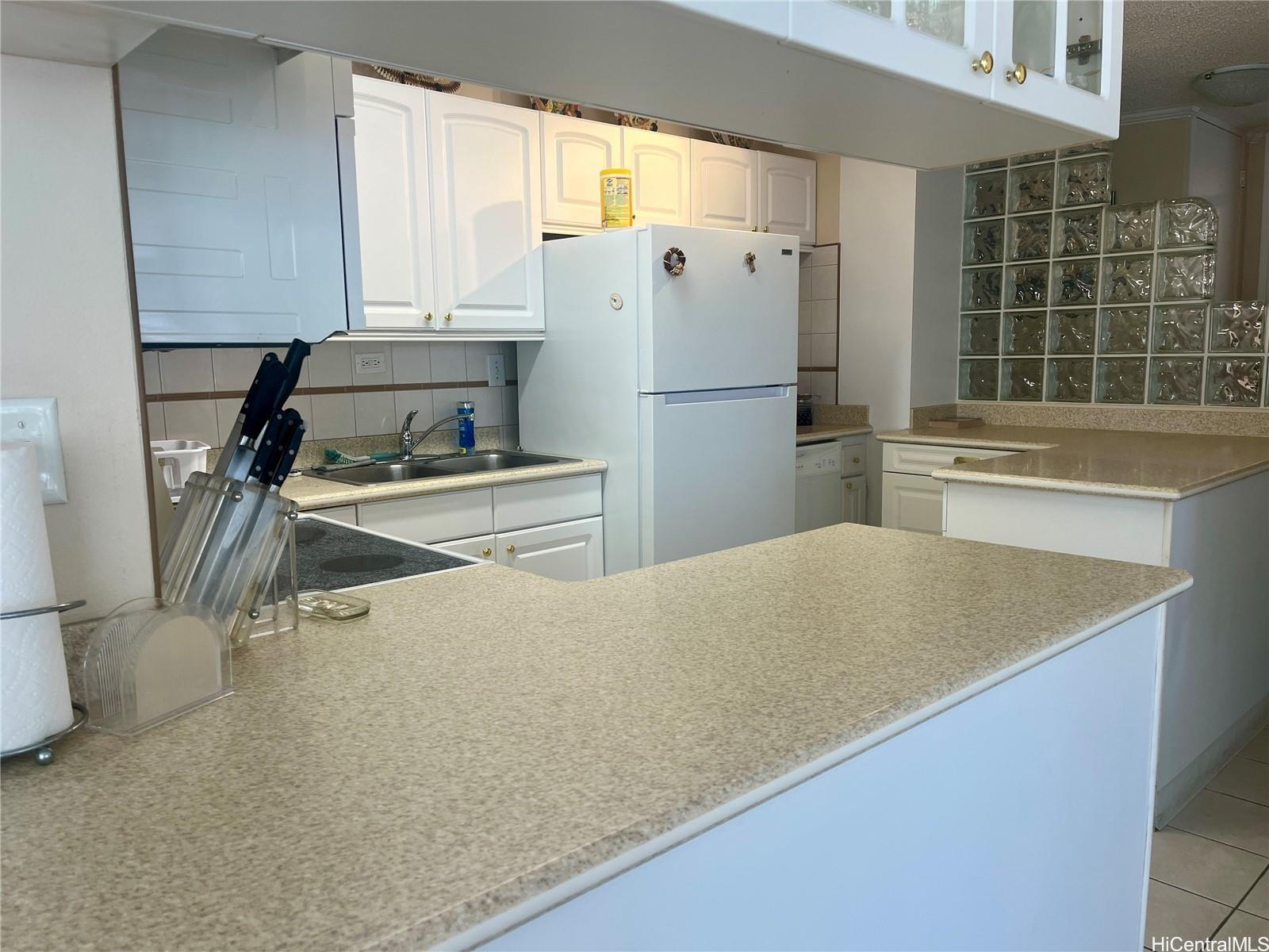 2415 Ala Wai Boulevard, Unit 1208 Honolulu, HI 96815 - Photo 12 of 13 a kitchen with stainless steel appliances a refrigerator a sink a stove and white cabinets