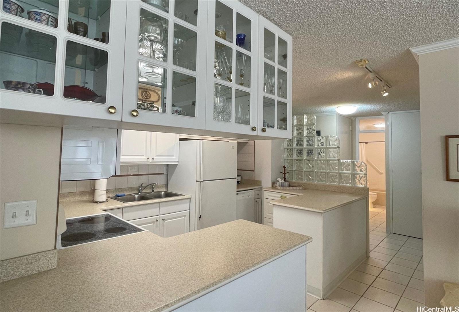 2415 Ala Wai Boulevard, Unit 1208 Honolulu, HI 96815 - Photo 4 of 13 a kitchen with a sink a stove and cabinets