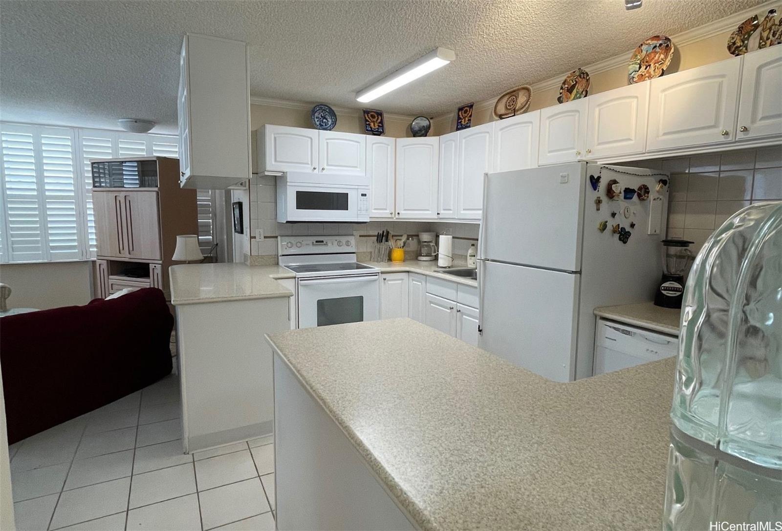 2415 Ala Wai Boulevard, Unit 1208 Honolulu, HI 96815 - Photo 5 of 13 a kitchen with stainless steel appliances a refrigerator sink and cabinets