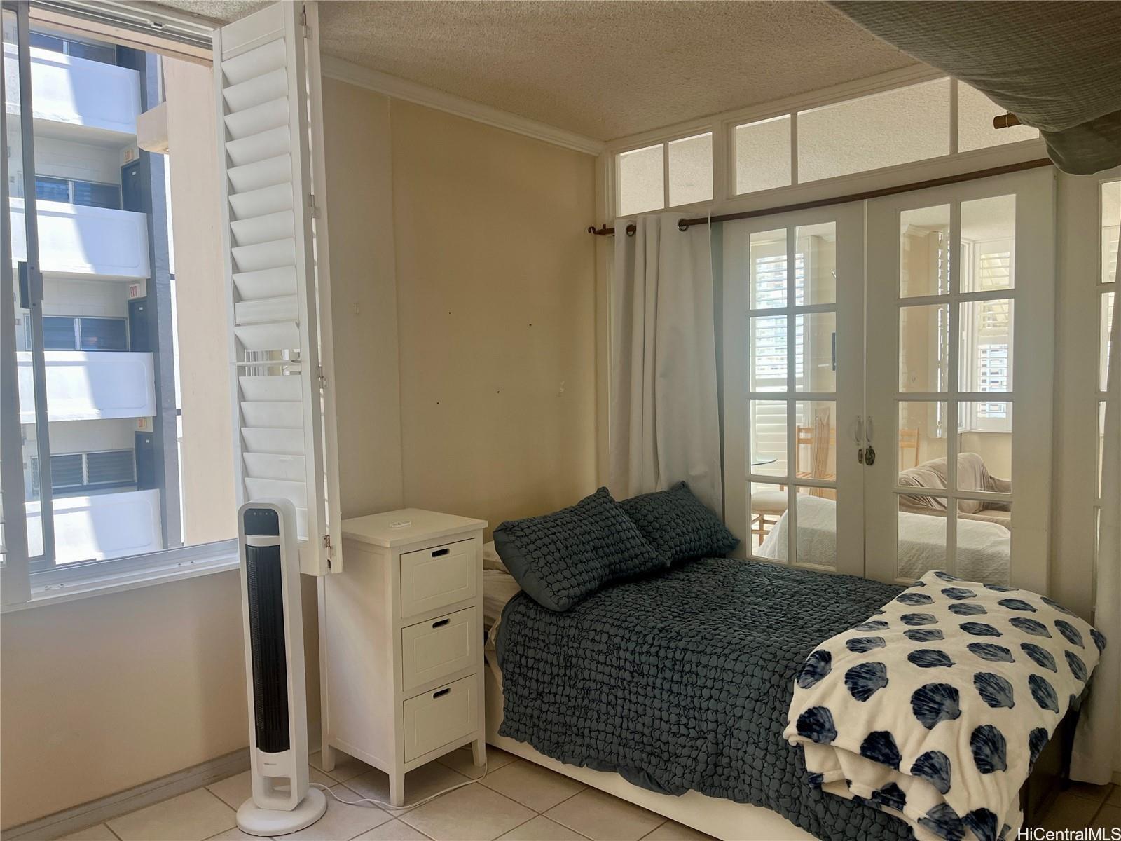 2415 Ala Wai Boulevard, Unit 1208 Honolulu, HI 96815 - Photo 9 of 13 a bedroom with a bed and a window