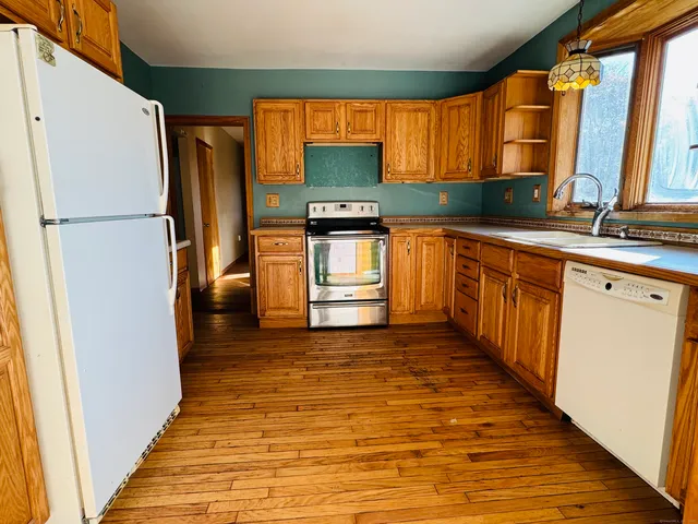 a kitchen with granite countertop a refrigerator and a sink