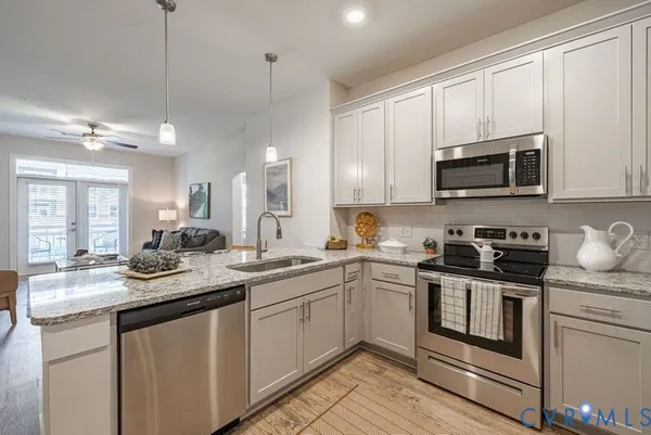 a kitchen with stainless steel appliances granite countertop a sink and stove top oven