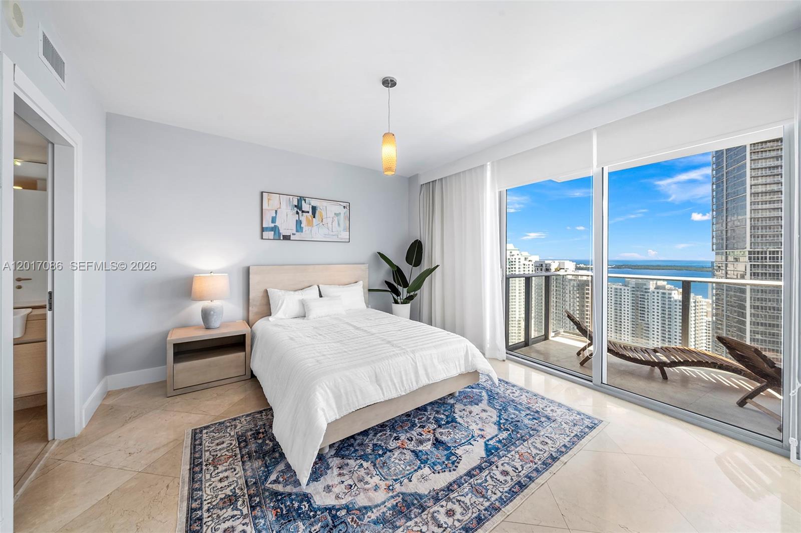 200 Biscayne Blvd Way, Unit 4308 Miami, FL 33131 - Photo 12 of 31 a bedroom with a large bed and a chandelier