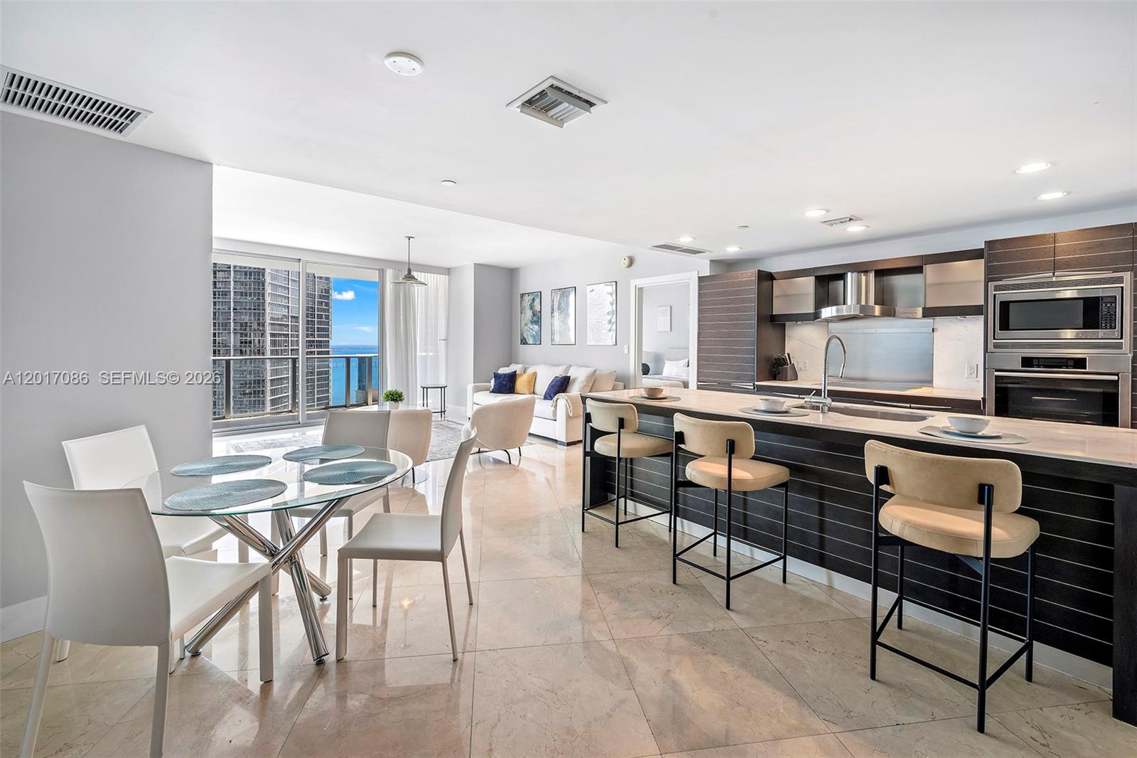 200 Biscayne Blvd Way, Unit 4308 Miami, FL 33131 - Photo 6 of 31 a kitchen with stainless steel appliances kitchen island granite countertop a stove a sink a dining table and chairs