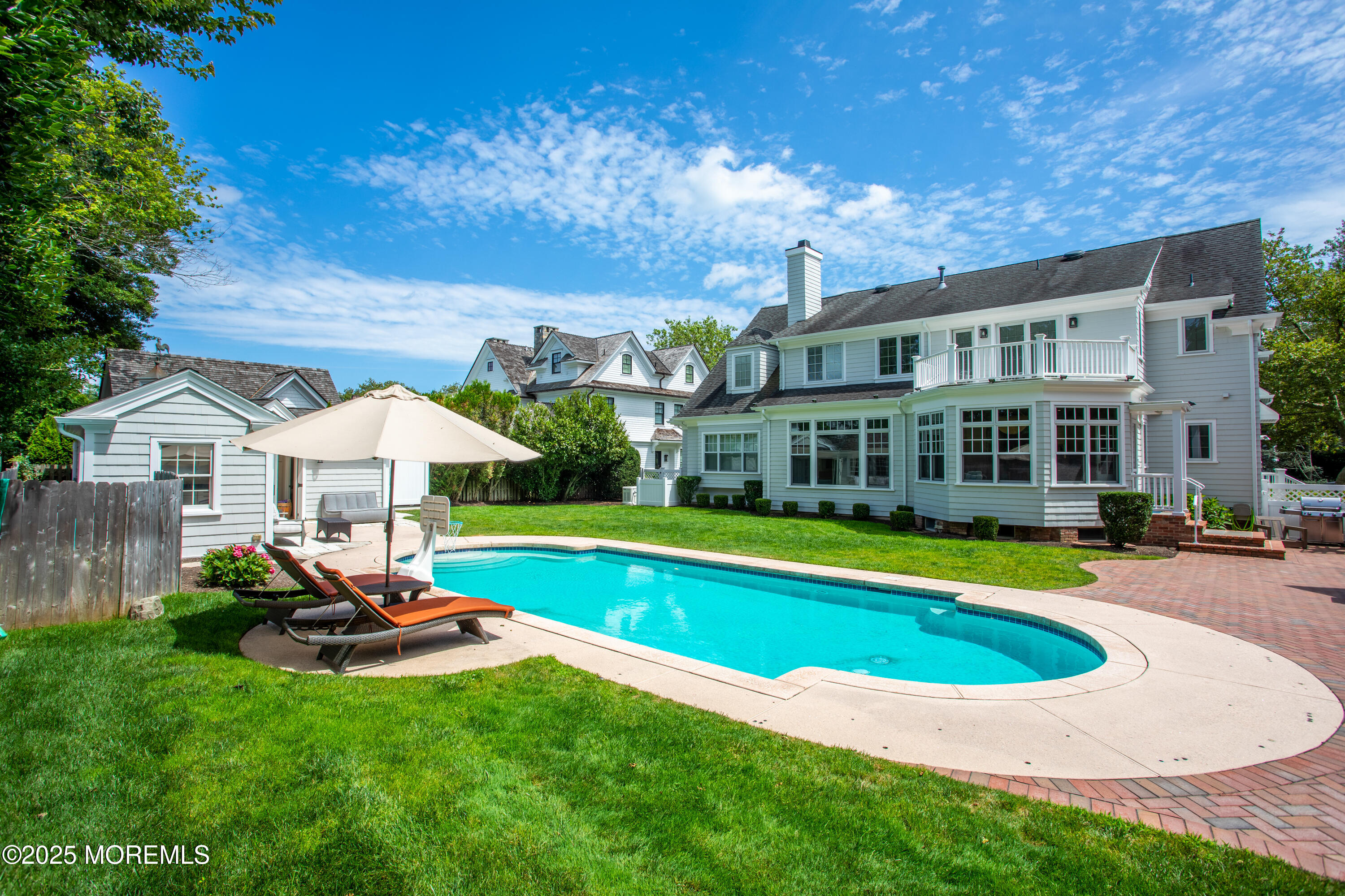 38 Vroom Avenue Spring Lake, NJ 07762 - Photo 2 of 15 a view of a swimming pool with lawn chairs under an umbrella