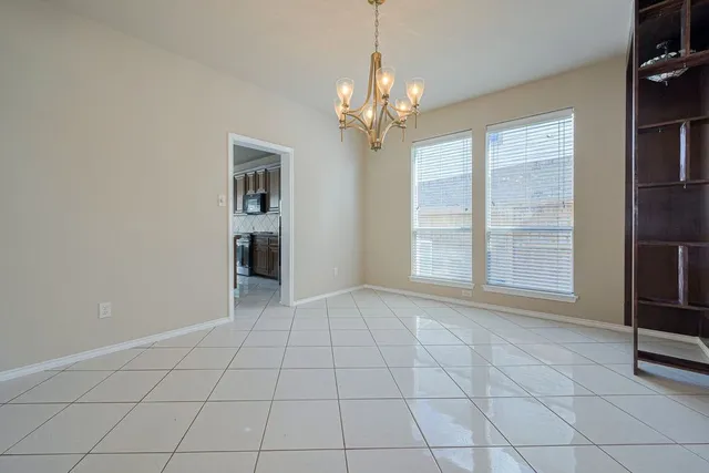 wooden floor in an empty room with a fireplace and a window