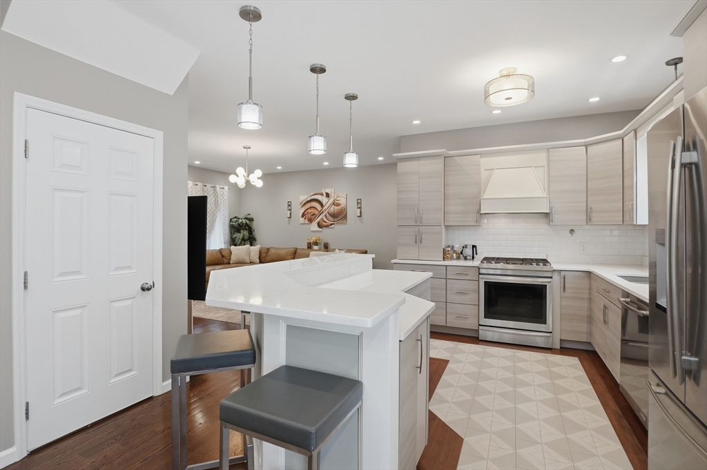 112 Pineland Avenue Worcester, MA 01604 - Photo 9 of 38 a kitchen with a stove a refrigerator a sink dishwasher with a dining table and chairs