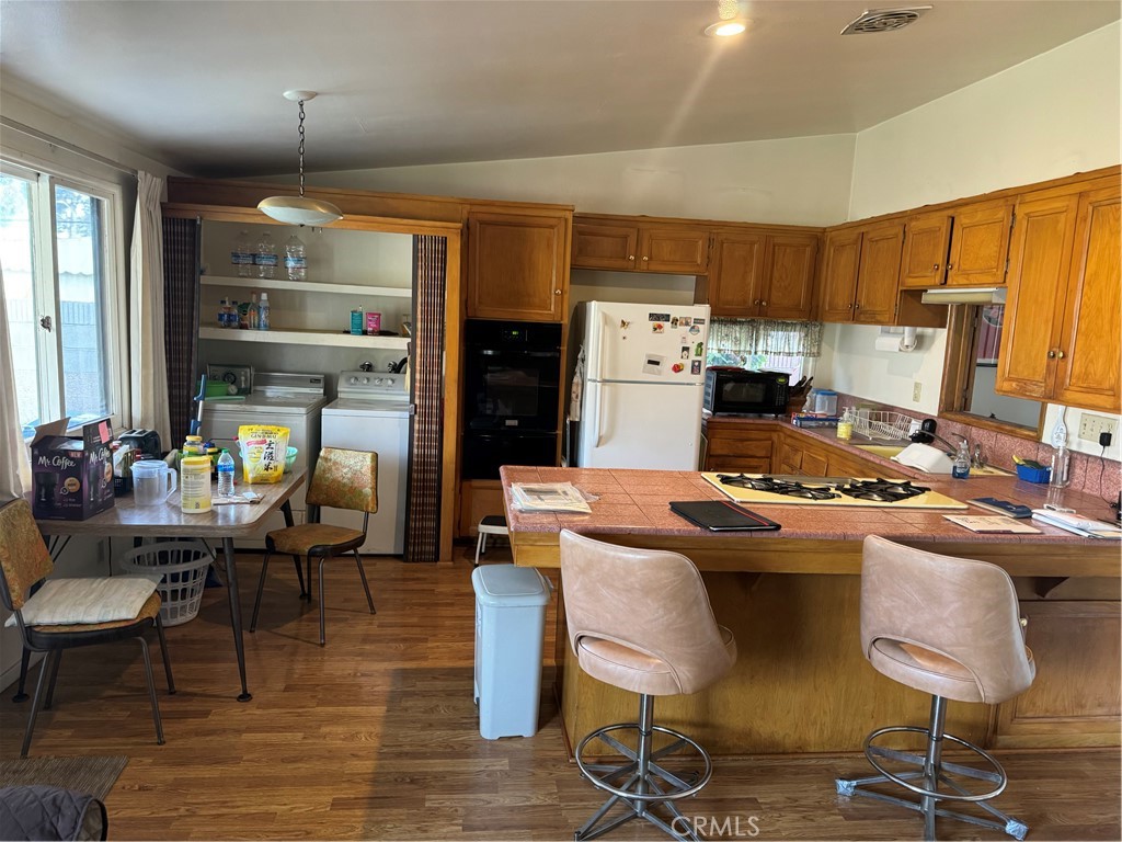 511 West 170th Street Gardena, CA 90248 - Photo 4 of 11 a kitchen with granite countertop a stove a refrigerator and wooden floor