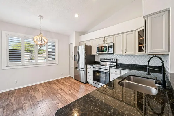a kitchen with stainless steel appliances granite countertop a stove refrigerator sink and microwave