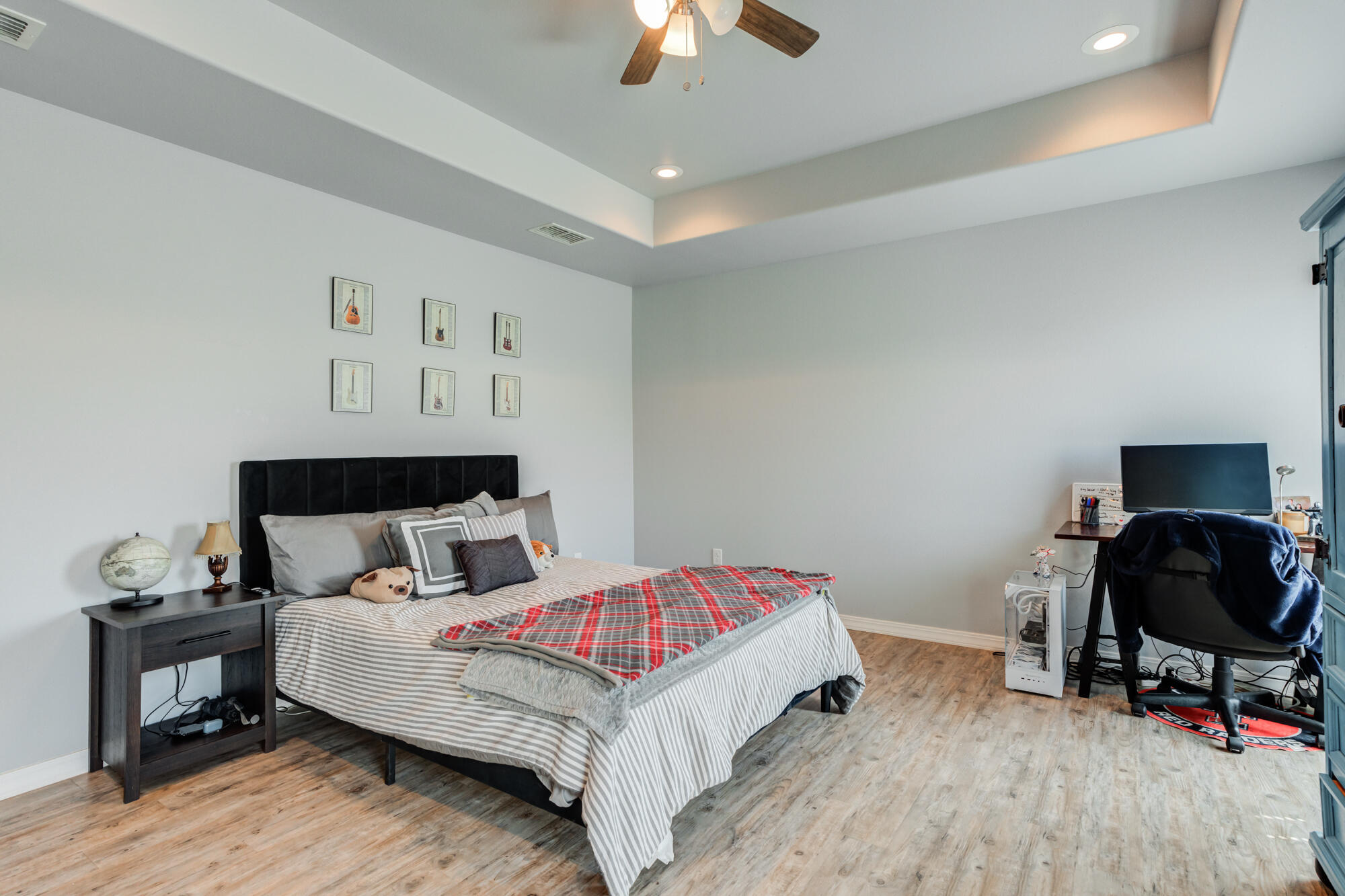 8801 15th Street Lubbock, TX 79416 - Photo 13 of 32 a bedroom with a bed and a chandelier
