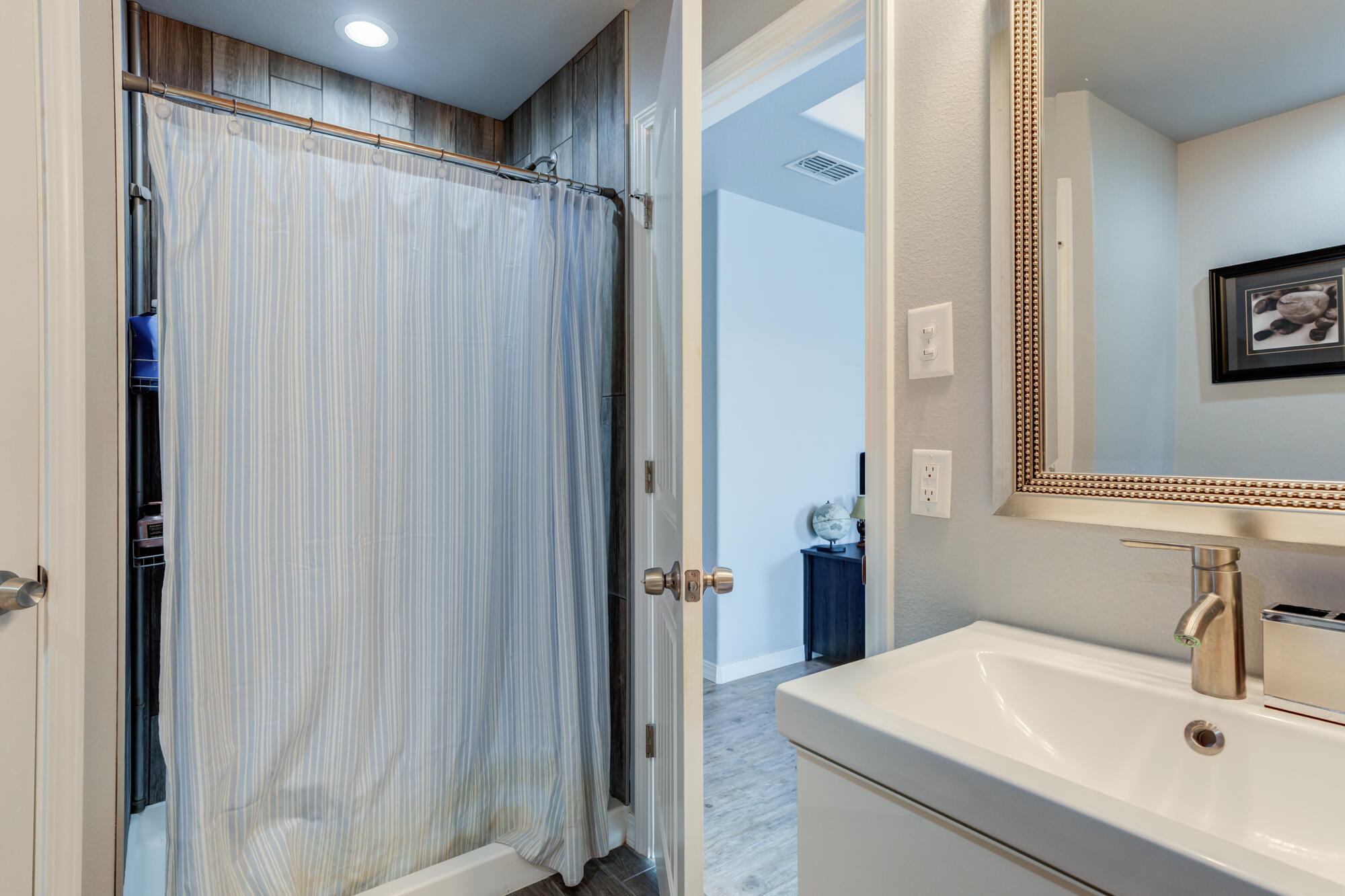 8801 15th Street Lubbock, TX 79416 - Photo 15 of 32 a bathroom with a sink and a mirror