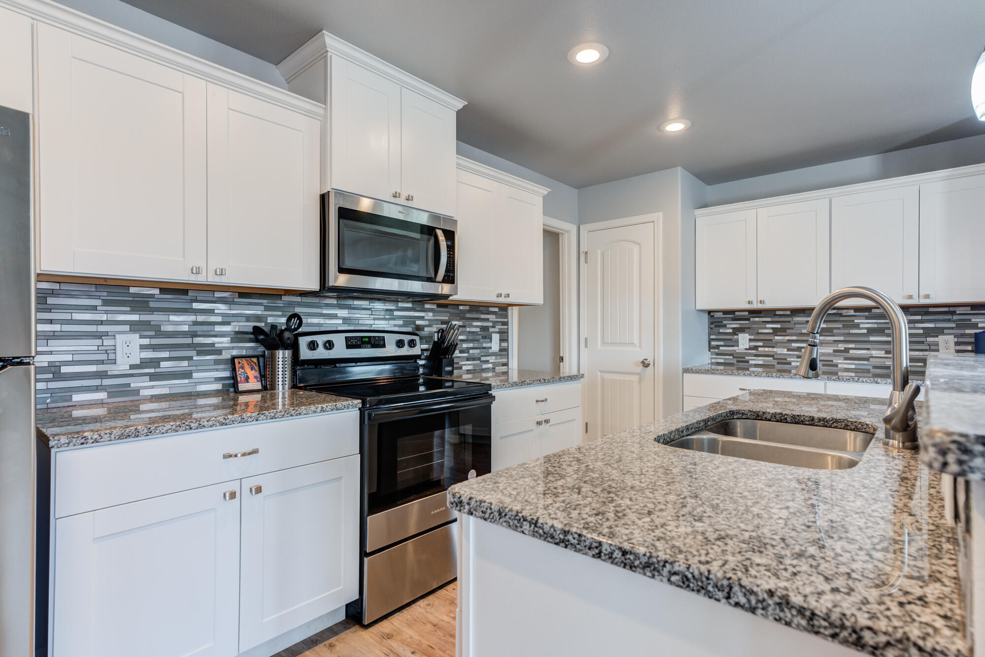 8801 15th Street Lubbock, TX 79416 - Photo 17 of 32 a kitchen with granite countertop a sink and stainless steel appliances