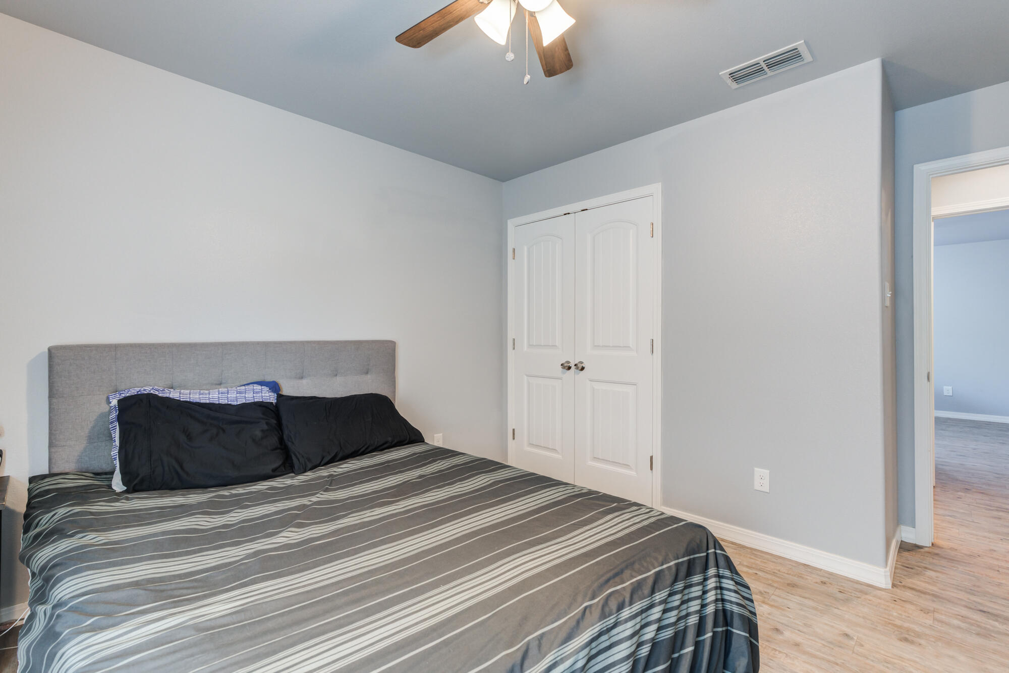 8801 15th Street Lubbock, TX 79416 - Photo 25 of 32 a bedroom with a bed and a chandelier fan