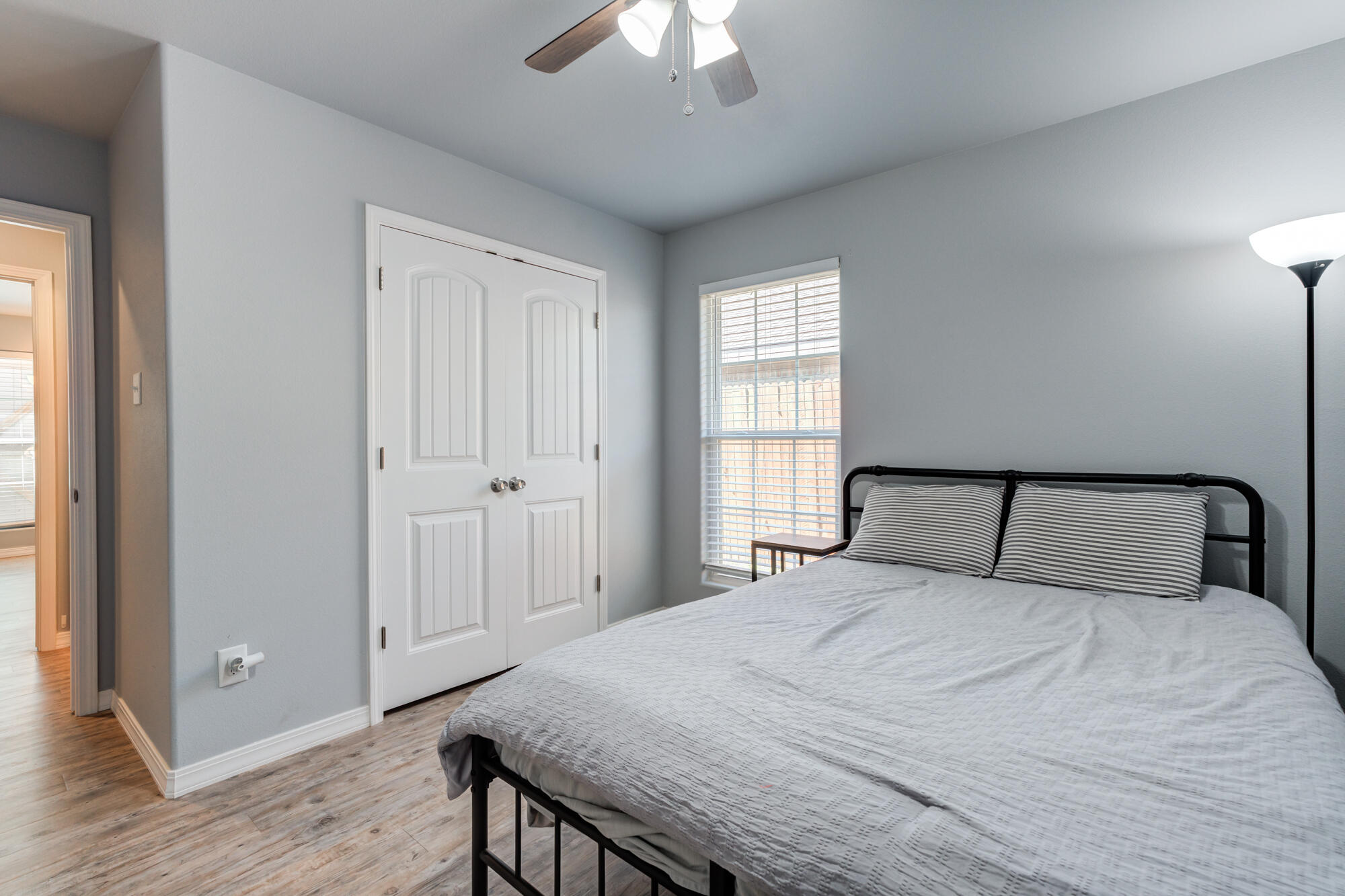 8801 15th Street Lubbock, TX 79416 - Photo 27 of 32 a bedroom with a large bed and a chandelier