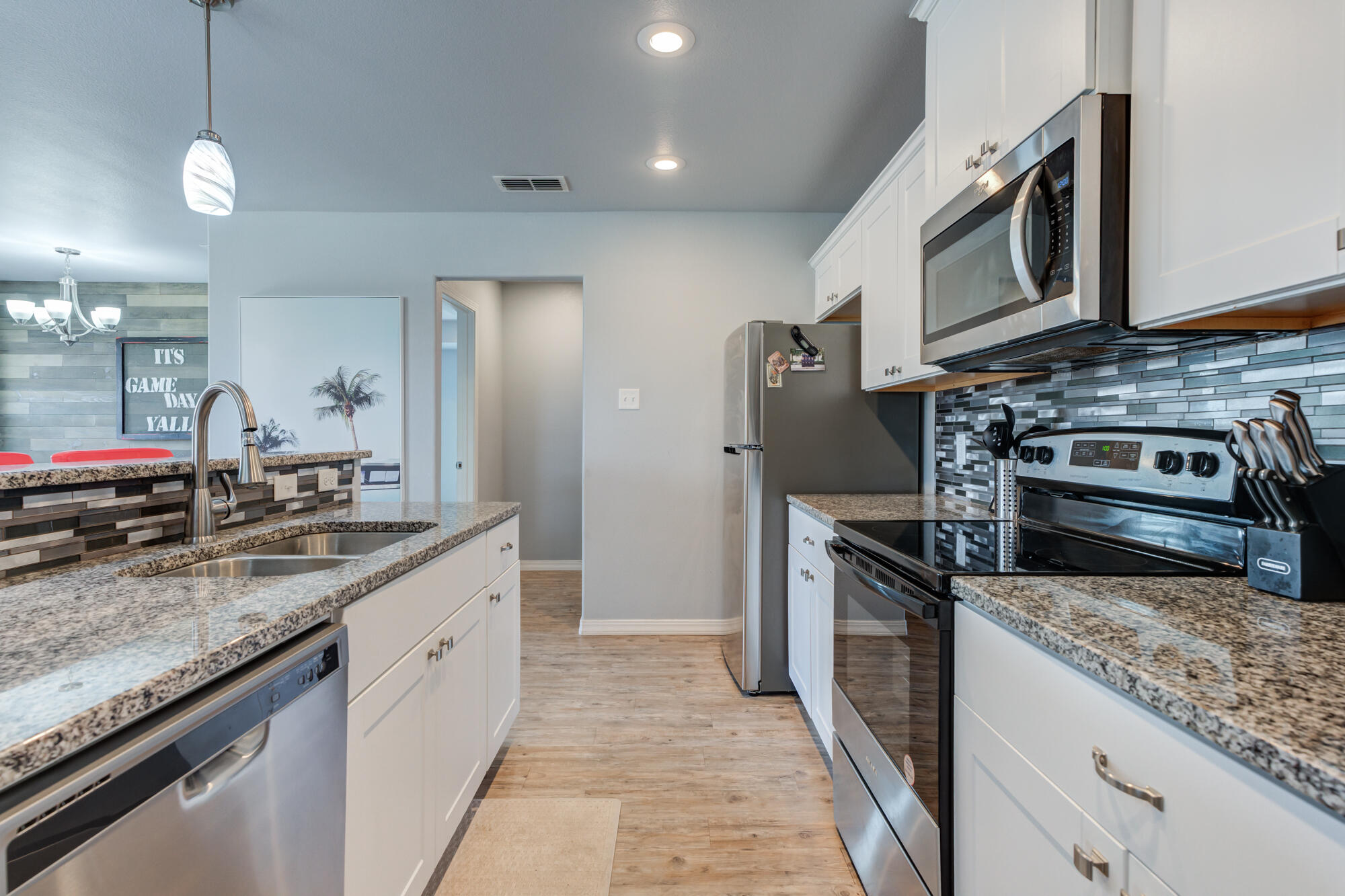 8801 15th Street Lubbock, TX 79416 - Photo 28 of 32 a kitchen with stainless steel appliances granite countertop a sink a stove and a refrigerator