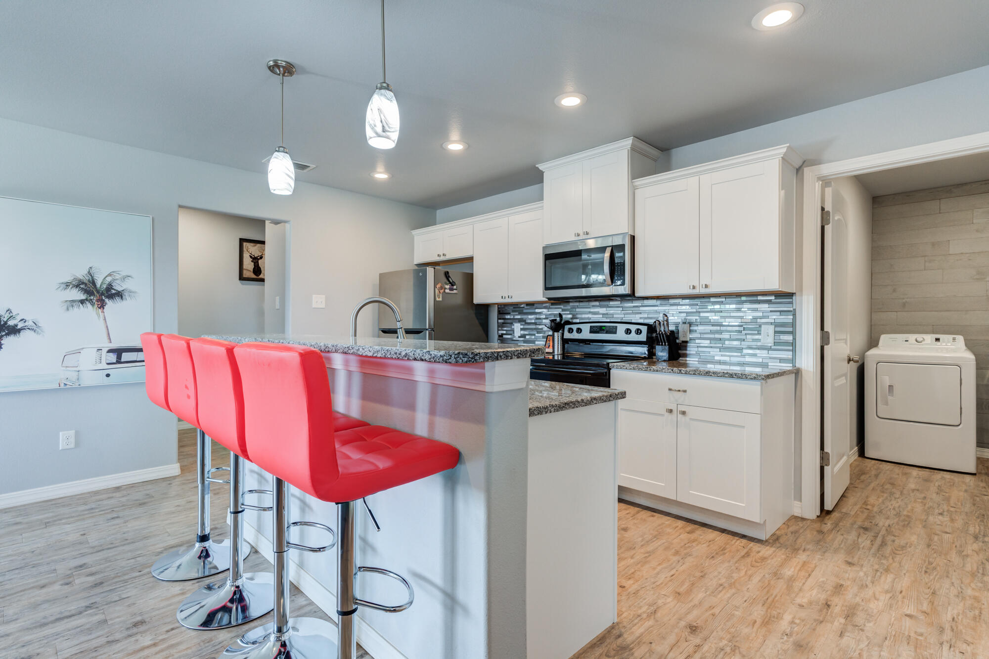 8801 15th Street Lubbock, TX 79416 - Photo 6 of 32 a kitchen with stainless steel appliances kitchen island granite countertop a sink dishwasher a stove a refrigerator with a dining table and chairs
