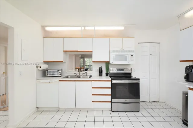 a kitchen with white cabinets stainless steel appliances and a sink