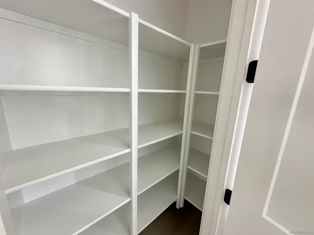 a view of walk in closet with empty racks