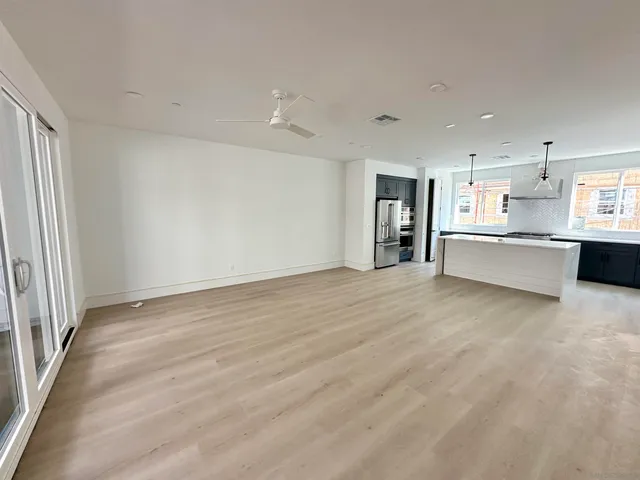 wooden floor in an empty room with a kitchen