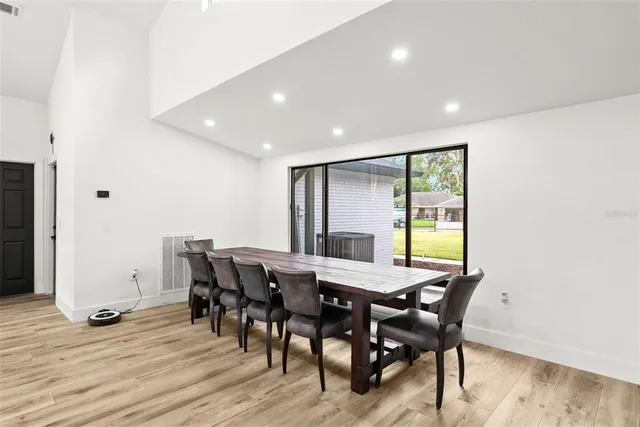 a kitchen with stainless steel appliances a dining table chairs and granite counter tops