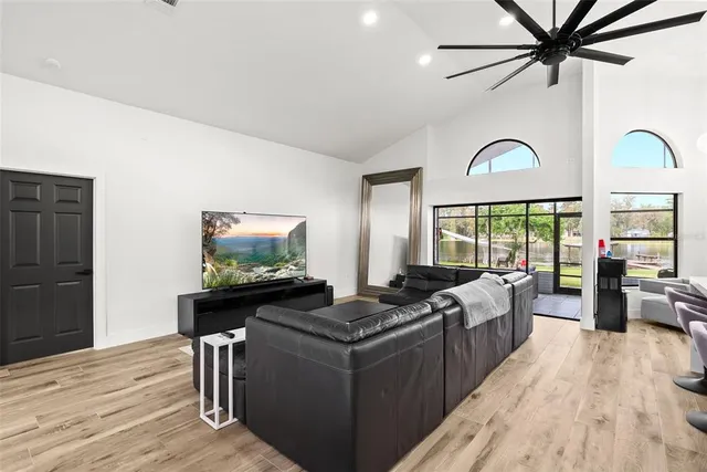 a kitchen with stainless steel appliances a refrigerator a stove a sink dishwasher a dining table and chairs with wooden floor