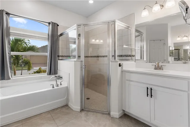 a bathroom with a shower sink vanity and mirror