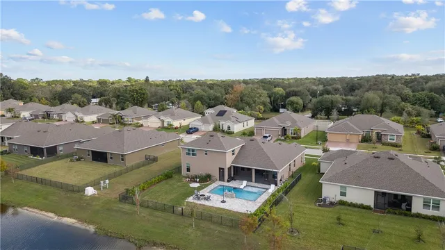 an aerial view of residential houses with outdoor space and trees
