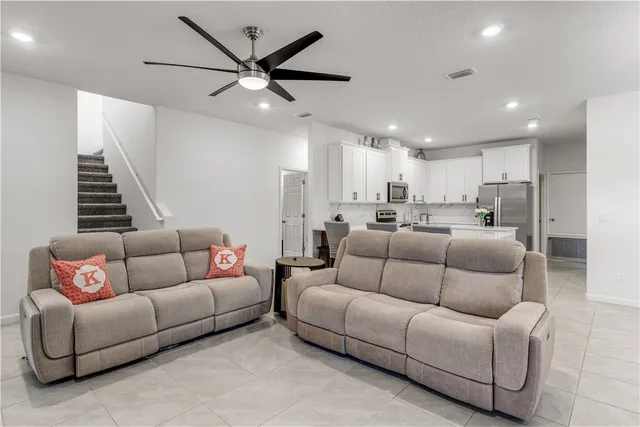 a living room with furniture and a ceiling fan
